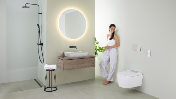 Femme devant le miroir de la salle de bains (© Geberit)