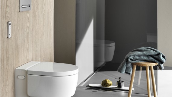 WC-douche Geberit AquaClean Mera Comfort avec télécommande et plaque de déclenchement Sigma50 (© Geberit) WC-douche Geberit AquaClean Mera Comfort avec télécommande et plaque de déclenchement Sigma50 (© Geberit)
