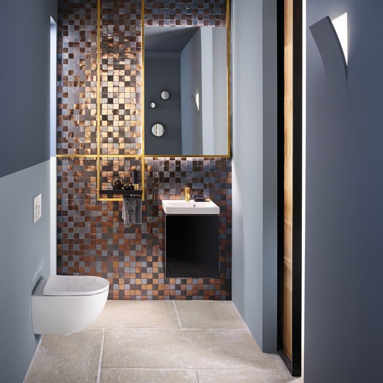Vue d'un WC d'invités moderne avec un WC Acanto et un lavabo Acanto devant un dosseret en mosaïque Vue d'un WC d'invités moderne avec un WC Acanto et un lavabo Acanto devant un dosseret en mosaïque