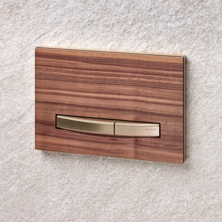 La plaque de commande Geberit Sigma50, avec sa surface en bois de noyer américain, s'intègre parfaitement dans une salle de bains de style nordique. La plaque de commande Geberit Sigma50, avec sa surface en bois de noyer américain, s'intègre parfaitement dans une salle de bains de style nordique.