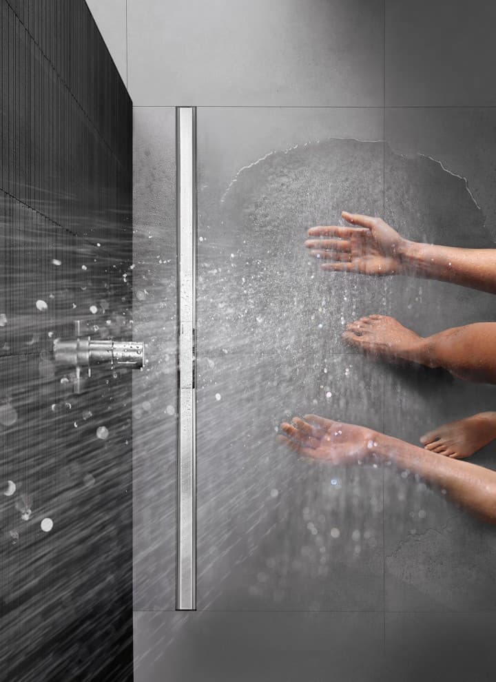 Personne se douchant dans une douche de plain-pied équipée du caniveau de douche Geberit CleanLine Personne se douchant dans une douche de plain-pied équipée du caniveau de douche Geberit CleanLine