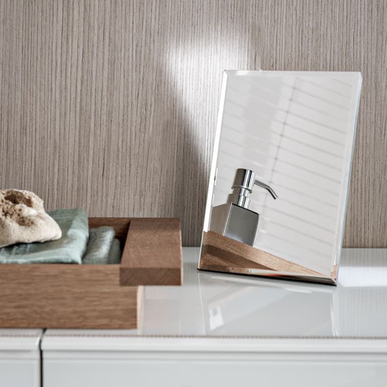 Un distributeur de savon se reflète dans un petit miroir décoratif Un distributeur de savon se reflète dans un petit miroir décoratif