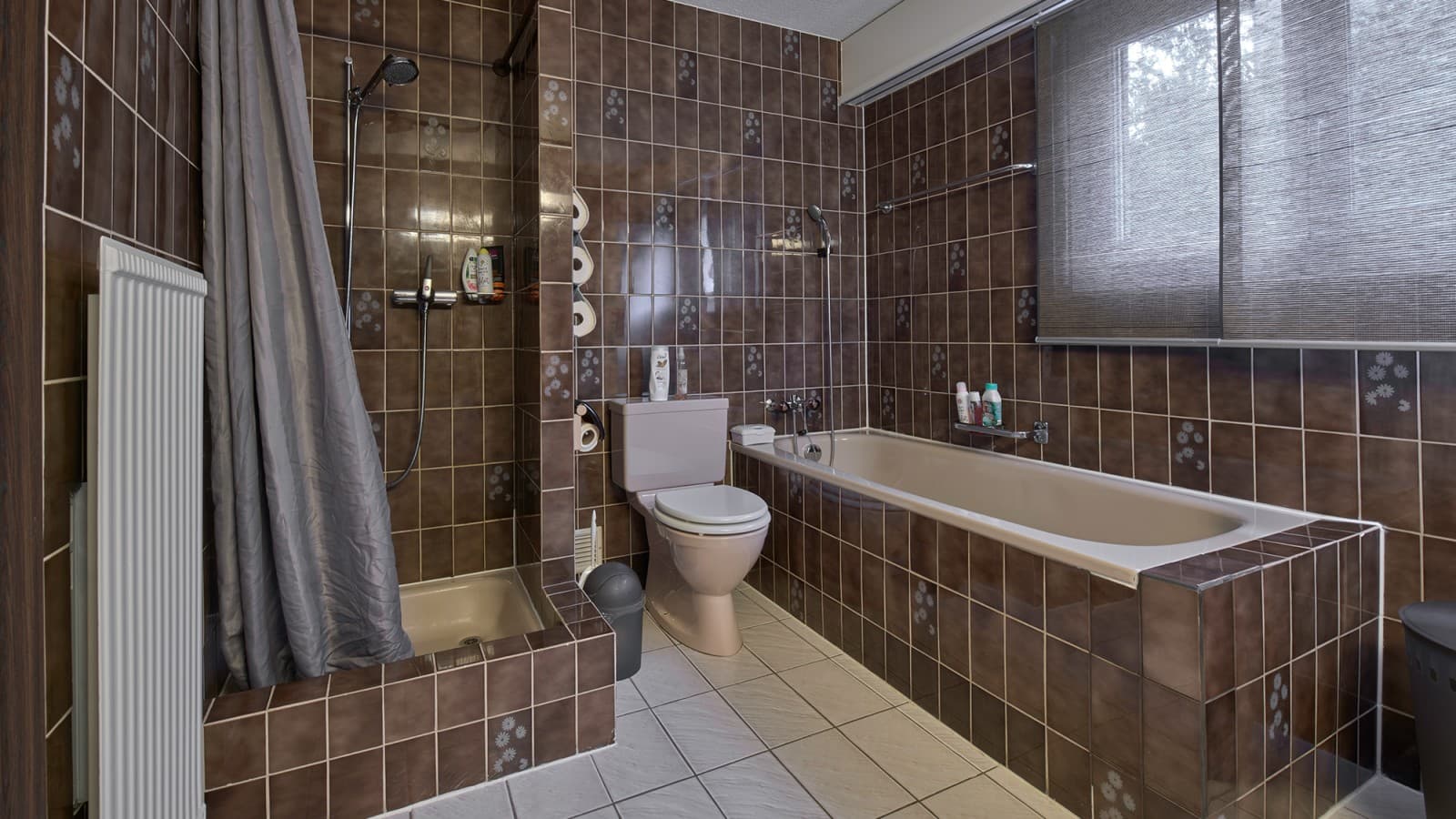 Salle de bains avec coin douche étroit, baignoire et WC au sol Salle de bains avec coin douche étroit, baignoire et WC au sol