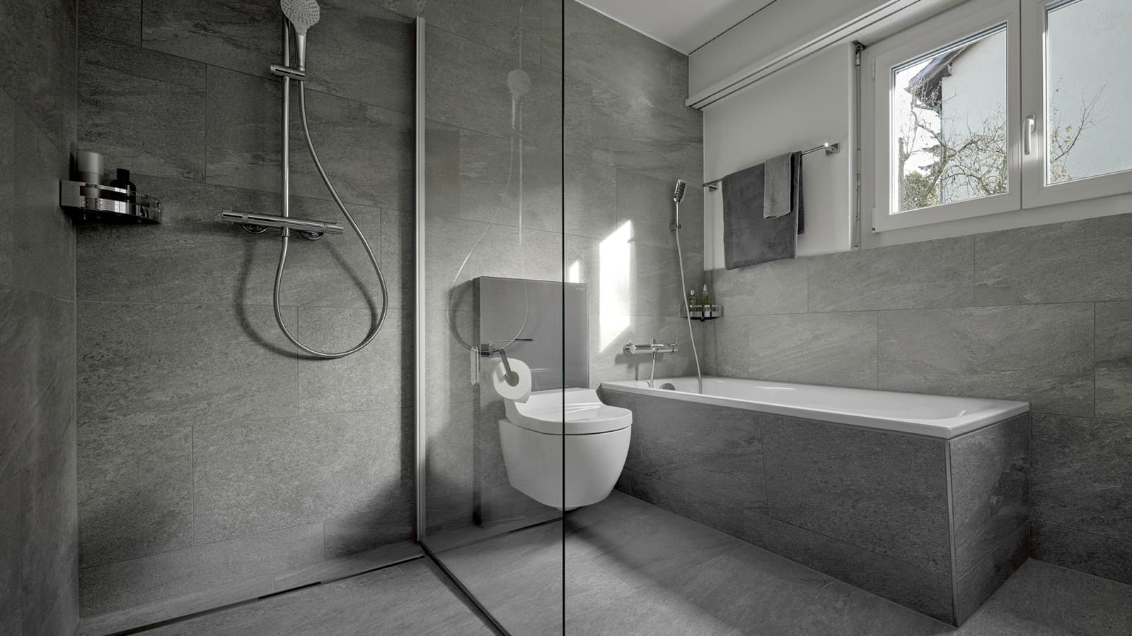 Un WC-douche entre une douche de plain-pied et une baignoire Un WC-douche entre une douche de plain-pied et une baignoire