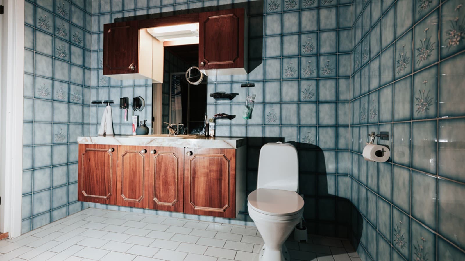 Salle de bains avec carrelage bleu et WC au sol Salle de bains avec carrelage bleu et WC au sol