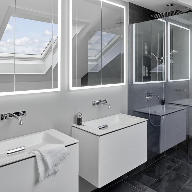 Salle de bains sous le toit avec deux lavabos et miroirs Salle de bains sous le toit avec deux lavabos et miroirs