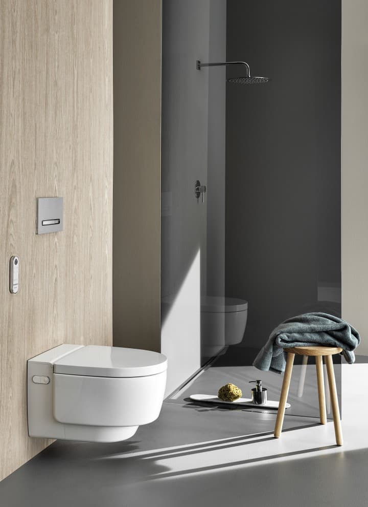 WC-douche Geberit AquaClean Mera Comfort avec télécommande et plaque de déclenchement Sigma50 (© Geberit) WC-douche Geberit AquaClean Mera Comfort avec télécommande et plaque de déclenchement Sigma50 (© Geberit)