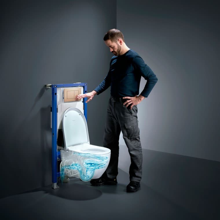 Un homme actionne la technologie de rinçage TurboFlush d'un WC Geberit Acanto Un homme actionne la technologie de rinçage TurboFlush d'un WC Geberit Acanto